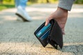 Man picking lost wallet from ground outdoors, closeup. Space for text