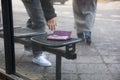 Man Picking Up A Lost Purse On Bench