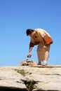 Man picking up rock - sin