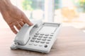 Man picking up telephone at table Royalty Free Stock Photo