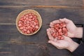 man picks broad bean seeds for sowing, heart-shaped hands with seeds on a wooden background