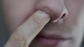 A man picks nasal mucus from his nostrils. Human disease rhinotillexomania, close-up