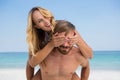 Man piggybacking playful woman at beach Royalty Free Stock Photo