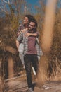 Man piggybacking woman on lake docks Royalty Free Stock Photo