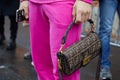 Man with pink trousers and brown Fendi bag with logo pattern before Etro fashion show, Milan