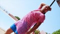 Man in pink tunics posing look in camera at beach umbrella. Wind. Summer sunny day. Blue sky