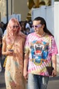 Man with pink and yellow tie dye shirt and woman with pink dress and hair before Dsquared2 show