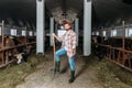 Man with pitchfork feeding cows