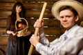 Man with pitchfork and in hat, woman with basket Royalty Free Stock Photo