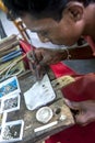 A man places a piece of moonstone into a ring at a factory in Mitiyagoda on the west coast of Sri Lanka.