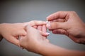 Man placing a diamond engagement ring on finger of his fiance Royalty Free Stock Photo