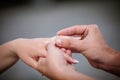 Man placing a diamond engagement ring on finger of his fiance Royalty Free Stock Photo