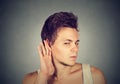 Man placing hand on ear listening carefully to gossip Royalty Free Stock Photo