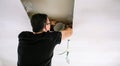 Man placing tube for kitchen hood installation on kitchen ceiling Royalty Free Stock Photo