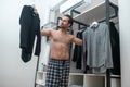 Man in plaid home pants choosing a shirt to wear Royalty Free Stock Photo