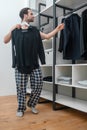 Man in plaid home pants choosing a shirt to wear Royalty Free Stock Photo