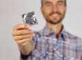 Man in plaid shirt holds a new condom in hand and smile, concept