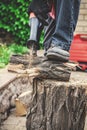 Man in plaid shirt sawing piece of wood on stump Royalty Free Stock Photo