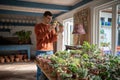 Man plant seller takes photos of potted plants on smartphone to sell online. Plant lover