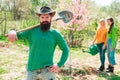 Man plants a tree, hands with shovel. Group of youth work in spring yard with garden tools. Friends plants and grows Royalty Free Stock Photo