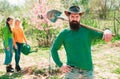 Man plants a tree, hands with shovel. Group of youth work in spring yard with garden tools. Friends plants and grows Royalty Free Stock Photo