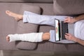 Man With Plastered Leg Using Laptop