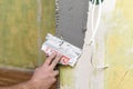 Man is plastering the wall. The process of applying the plastic mixture to the perforated corners. Align walls and corners Royalty Free Stock Photo