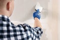 Man plastering wall with putty knife indoors, closeup. Home renovation Royalty Free Stock Photo