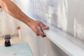 Man plastering a wall using floating rule to check the flatness Royalty Free Stock Photo