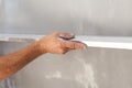 Man plastering a wall using floating rule to check the flatness. Royalty Free Stock Photo