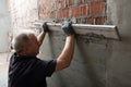 Man plastering wall. Worker makes renovation. Construction work Royalty Free Stock Photo