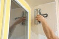 Man plastering window area with putty knife, closeup. Interior repair