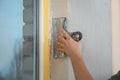 Man plastering window area with putty knife indoors. Interior repair