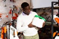 Man with plastic canister in gardening tools store