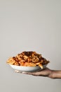 Man with a plate of pasta with tomato sauce