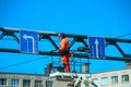 A man on a platform painting a rack for traffic signs Royalty Free Stock Photo