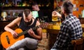 Man play guitar in bar. Friday relaxation in bar. Friends relaxing in bar or pub. Hipster brutal bearded spend leisure Royalty Free Stock Photo
