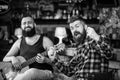 Man play guitar in pub. Live music concert. Acoustic performance in pub. Hipster brutal bearded with friend in pub Royalty Free Stock Photo