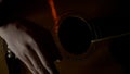 Man playing acoustic guitar in a dark room, concept of music and creativity. HDR. Close up view of male fingers playing Royalty Free Stock Photo