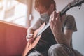 Man playing acoustic guitar in home quarantine self-isolation Royalty Free Stock Photo