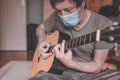 Man playing acoustic guitar in home quarantine self-isolation Royalty Free Stock Photo