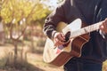 Man playing an acoustic guitar in the park