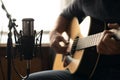 Man playing acoustic guitar and recording with a microphone in a room. Home studio Royalty Free Stock Photo