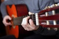 Man playing with acoustic orange guitar. the art of playing a stringed classical musical instrumentn Royalty Free Stock Photo