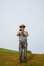 A man playing the trumpet at a park. 