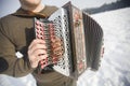 Man is playing on beautiful old harmonica accordion in winter nature Royalty Free Stock Photo