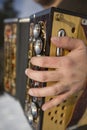 Man is playing on beautiful old harmonica accordion in winter nature Royalty Free Stock Photo