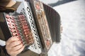 Man is playing on beautiful old harmonica accordion in winter nature Royalty Free Stock Photo