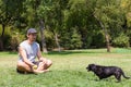 Man Playing With Black Dog Showing Him Tennis Ball At Park