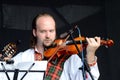 Man playing celtic medieval music in traditional scottish clothes